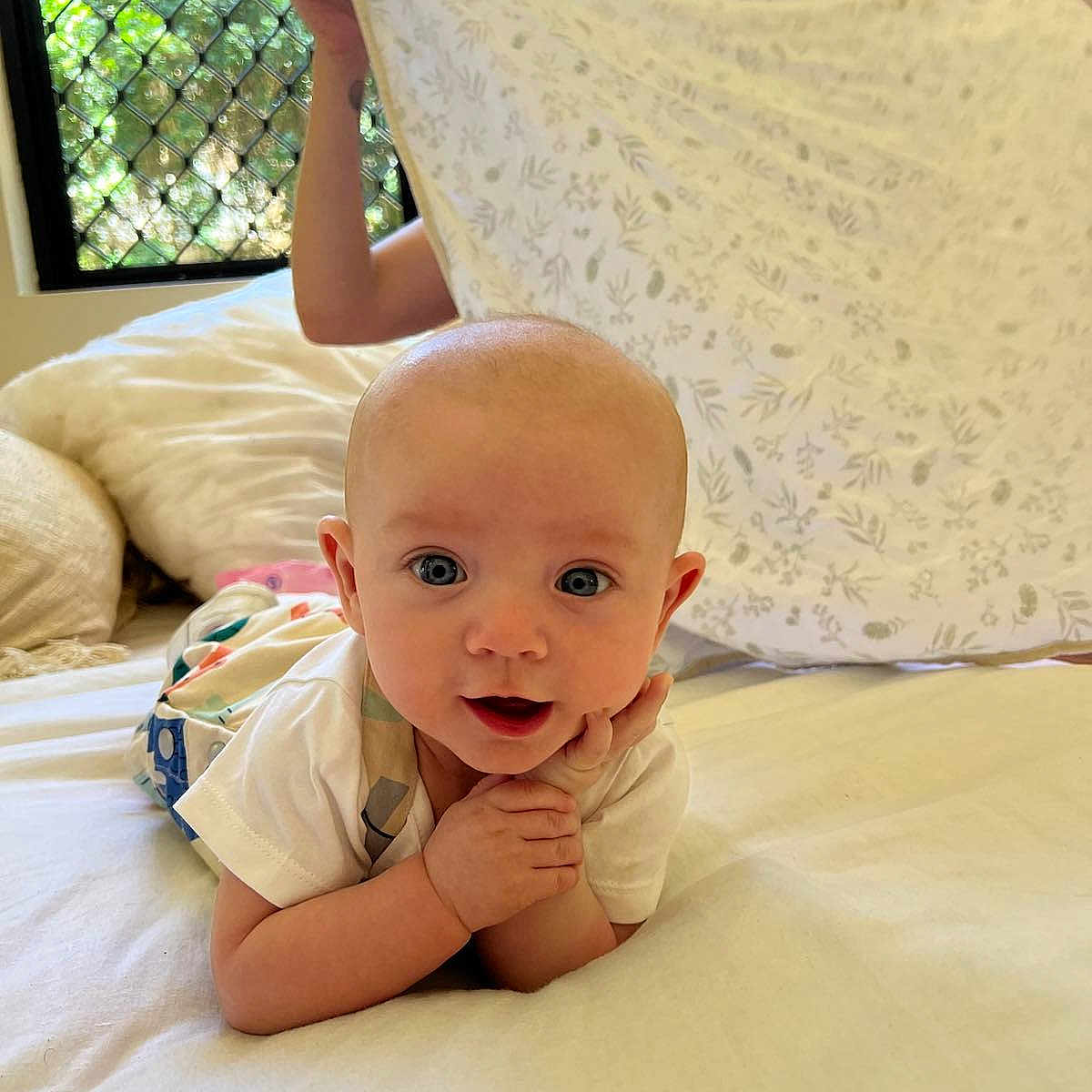 Hudson is registered to the contest to win money with this photo: baby, bed, bedroom, bodypart, clothing, couch, cushion, face, finger, furniture, happy, head, homedecor, indoors, person, photography, portrait, quilt, room, t_shirt