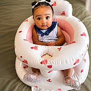 Ayla joined the competition — help win amazing prizes! baby, infant, child, sitting, inflatable_seat, pink, white, bunny_prints, pigtails, hair_bows, blue_collar, striped_clothing, indoor, cute, wide_eyes, plastic_shoes, bed, blanket, portrait, adorable