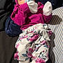Samiya is registered to the contest to win money with this photo: baby, infant, pacifier, headband, mittens, floral_pants, socks, blanket, cushion, clothing, lying_down, comfortable, indoor, cute, newborn, child, person, portrait, resting, colorful
