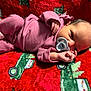 newborn, baby, infant, pacifier, pink_pajamas, blanket, red_blanket, holiday_theme, christmas, resting, lying_down, soft_texture, cute, small_hands, face, head, sleepwear, child, indoors, cozy