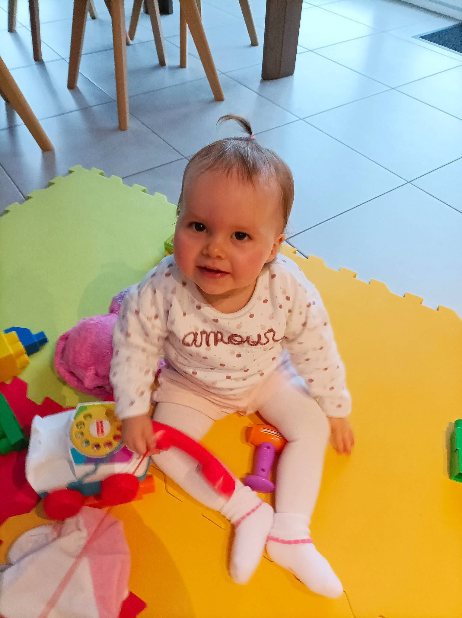 Louane participe au concours pour gagner de l'argent avec cette photo : baby, baby_playing_with_toys, baby_products, baby_toddler_clothing, chair, cheek, child, comfort, flooring, fun, happy, hardwood, person, play, room, sitting, skin, sleeve, smile, toddler