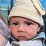 Ignacio is registered to the contest to win money with this photo: baby, beige, bunny_ears, child, close_up, clothing, cute, eyes, face, hat, headwear, infant, outdoor, person, portrait, serious, skin, soft_lighting, window, young