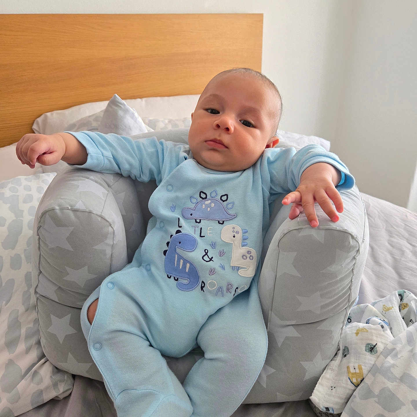 Ignacio joined the competition — help win amazing prizes! baby, baby_seat, bed, blanket, blue_clothing, child, cute, dinosaur, indoor, infant, newborn, onesie, person, pillow, portrait, relaxed, resting, sleepwear, soft_fabric, star_pattern