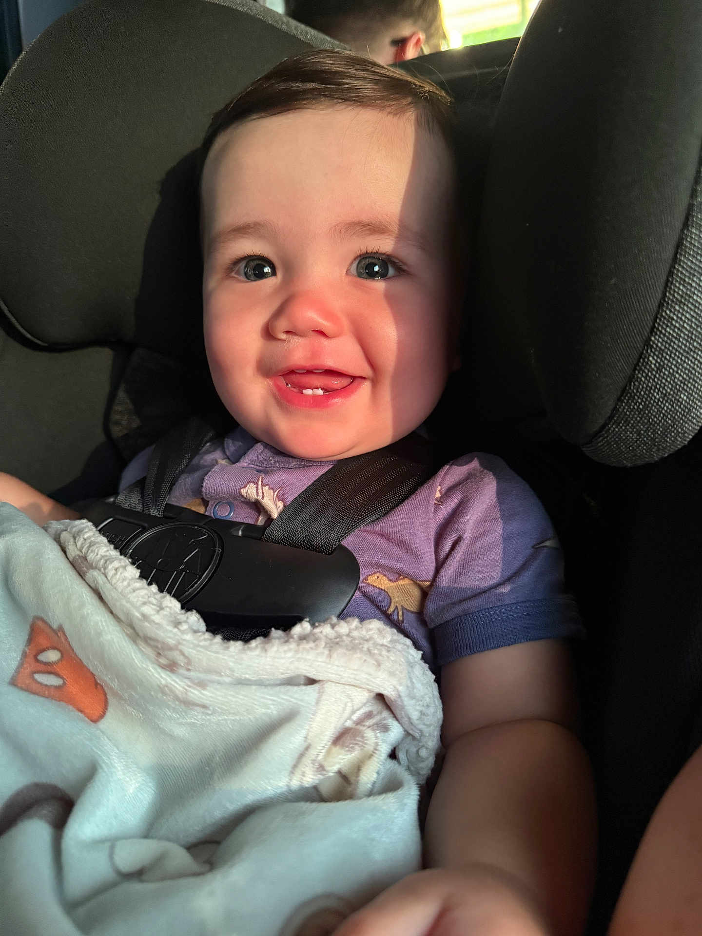 Axial joined the competition — help win amazing prizes! baby, child, car_seat, blanket, smile, teeth, sunlight, shadow, purple_shirt, infant, seatbelt, cute, happy, indoor, portrait, close_up, person, young_child, warm_light, cozy