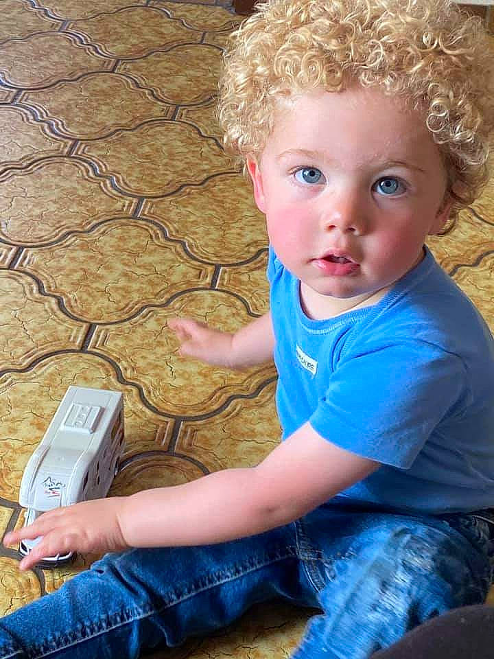 Esteban participe au concours pour gagner de l'argent avec cette photo : afro, baby_toddler_clothing, blond, child, denim, finger, flooring, fun, gadget, grass, happy, leisure, mobile_phone, person, ringlet, sitting, skin, soil, t_shirt, toddler