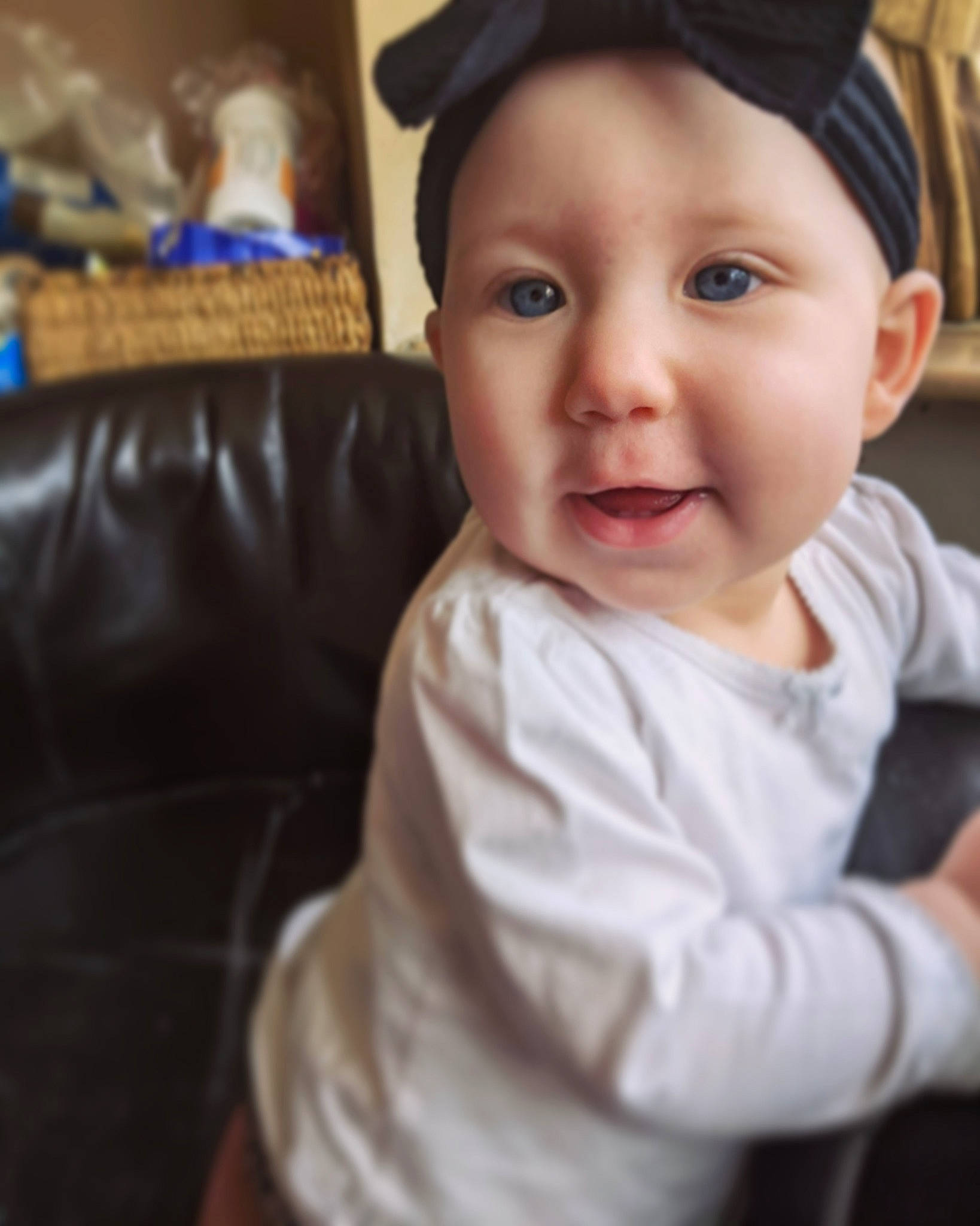 Emilee is registered to the contest to win money with this photo: baby, baby_toddler_clothing, black, cap, cheek, child, couch, eyebrow, eyelash, fashion_accessory, fun, happy, hat, iris, lip, nose, person, sitting, sleeve, smile