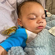 Zahkyrie joined the competition — help win amazing prizes! baby, sleeping, blanket, pacifier, curly_hair, bed, cozy, child, infant, blue_clothing, soft_texture, closeup, peaceful, resting, indoors, cute, portrait, comfort, toddler, naptime