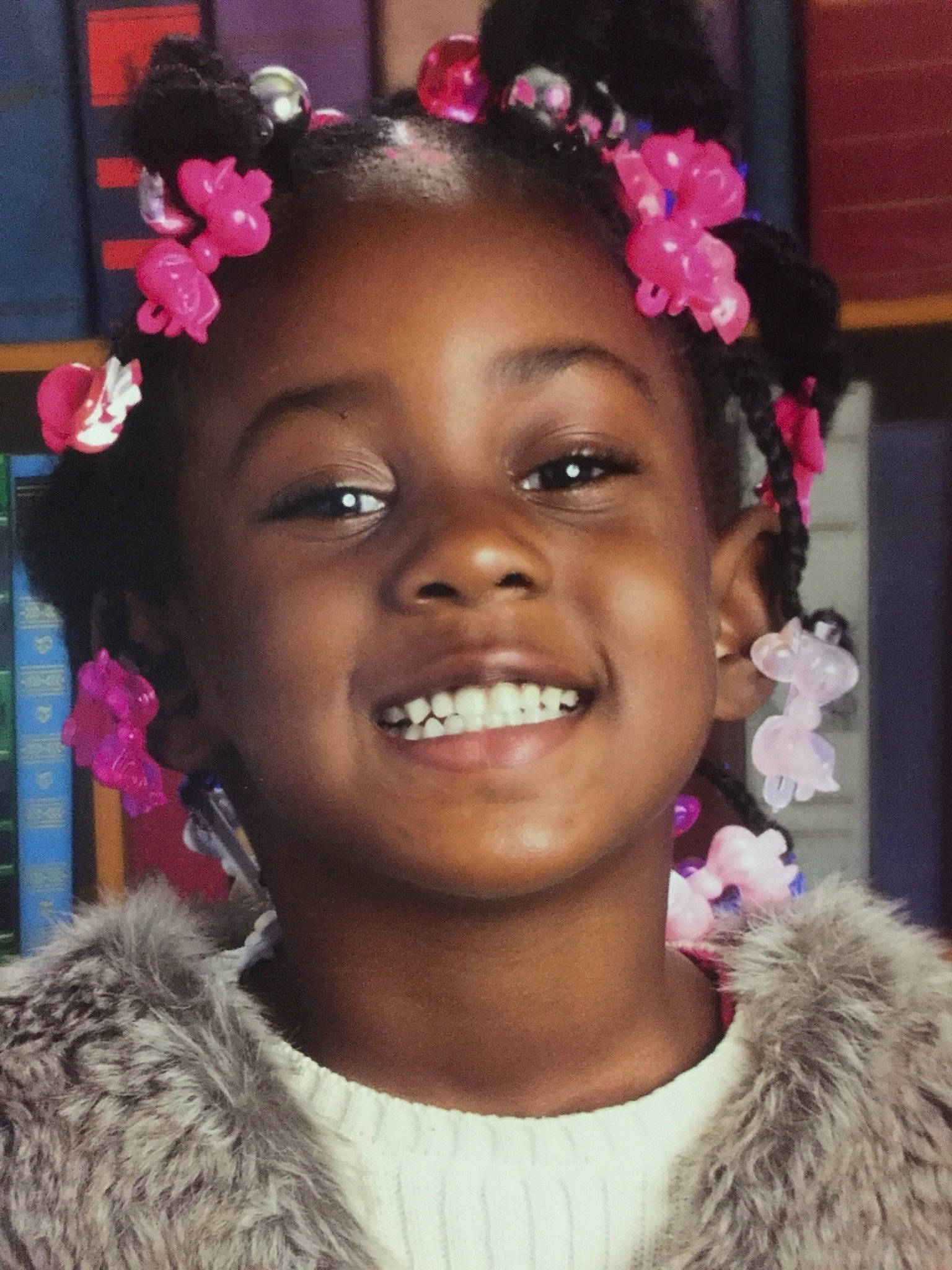 Nailah is registered to the contest to win money with this photo: afro, cheek, child, flower, fun, girl, hair, hair_accessory, hair_coloring, hairstyle, happiness, headpiece, joy, person, pink, smile, temple, tradition