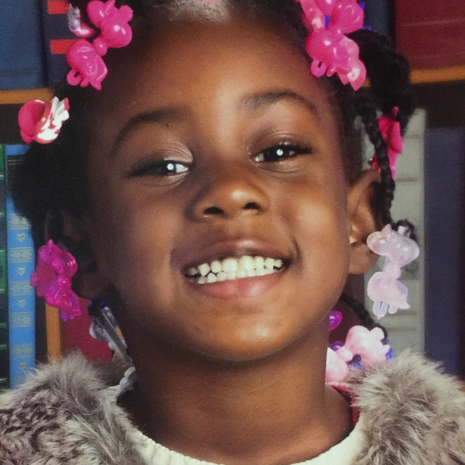 Nailah is registered to the contest to win money with this photo: afro, cheek, child, flower, fun, girl, hair, hair_accessory, hair_coloring, hairstyle, happiness, headpiece, joy, person, pink, smile, temple, tradition