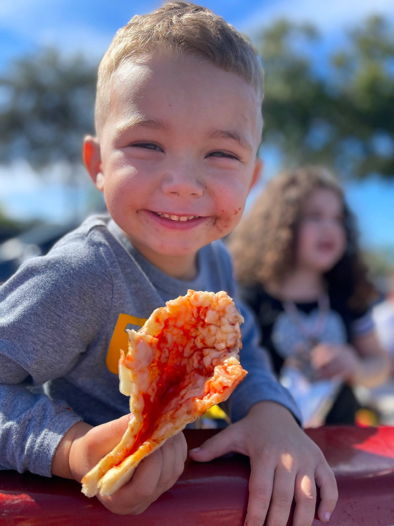 Kai is registered to the contest to win money with this photo: blurred, child, comfort_food, cuisine, dish, eating, finger, finger_food, food, food_craving, fun, hand, happy, ingredient, joy, junk_food, orange, people_in_nature, person, sky