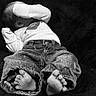 baby, infant, feet, denim_pants, long_sleeve_shirt, black_and_white, laying_down, cozy, soft_texture, child, cute, small, toes, clothing, covering_face, relaxed, portrait, indoor, young, sleeping_position