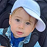 child, toddler, baby, face, hat, cap, blue_shirt, striped_shirt, stroller, seatbelt, portrait, cute, curious, outdoor, person, young_child, fashion, casual, closeup, headwear