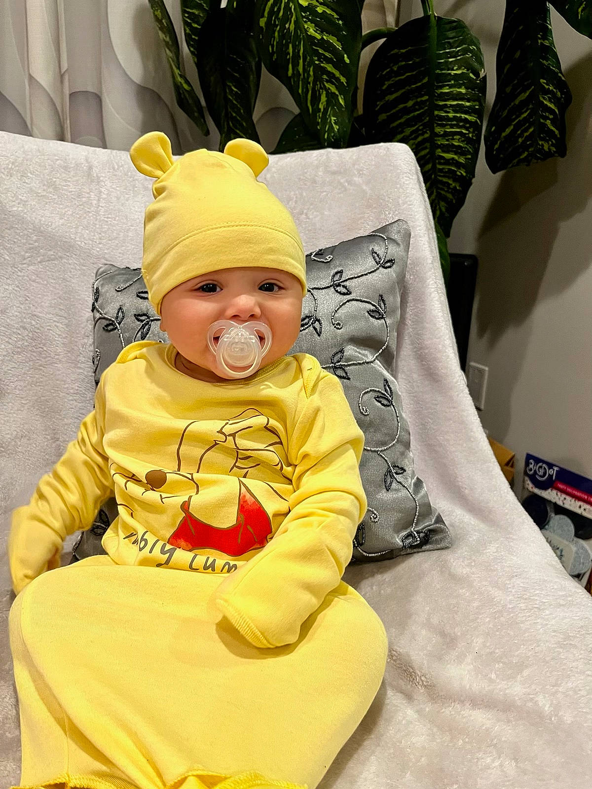 Elian joined the competition — help win amazing prizes! baby, baby_products, baby_safety, baby_toddler_clothing, cap, cheek, child, comfort, costume_hat, hat, headgear, headwear, houseplant, linens, person, plant, product, room, sitting, sleeve