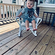 Grayson joined the competition — help win amazing prizes! baby, barefoot, child, curious, daylight, expression, face, grey_clothing, outdoor, person, porch, railing, rocking_chair, shirt, shorts, sitting, toddler, wicker_chair, window, wooden_floor
