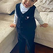 William a rejoint le concours — aidez-le/la à gagner de superbes lots ! toddler, child, smiling, standing, indoor, couch, sofa, clothing, vest, shirt, pants, shoes, floor, wooden_floor, cute, happy, person, face, mickey_mouse, puma