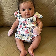 Brielle is registered to the contest to win money with this photo: baby, infant, child, girl, sitting, dress, floral, mittens, hair_bow, couch, quilted, beige, cute, portrait, indoor, skin, feet, face, eyes, expression