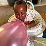 baby, balloon, child, cushion, hair, infant, indoor, person, pink, seat, toy, young_child, curious, baby_seat, carpet, home, playing, skin, clothing, closeup
