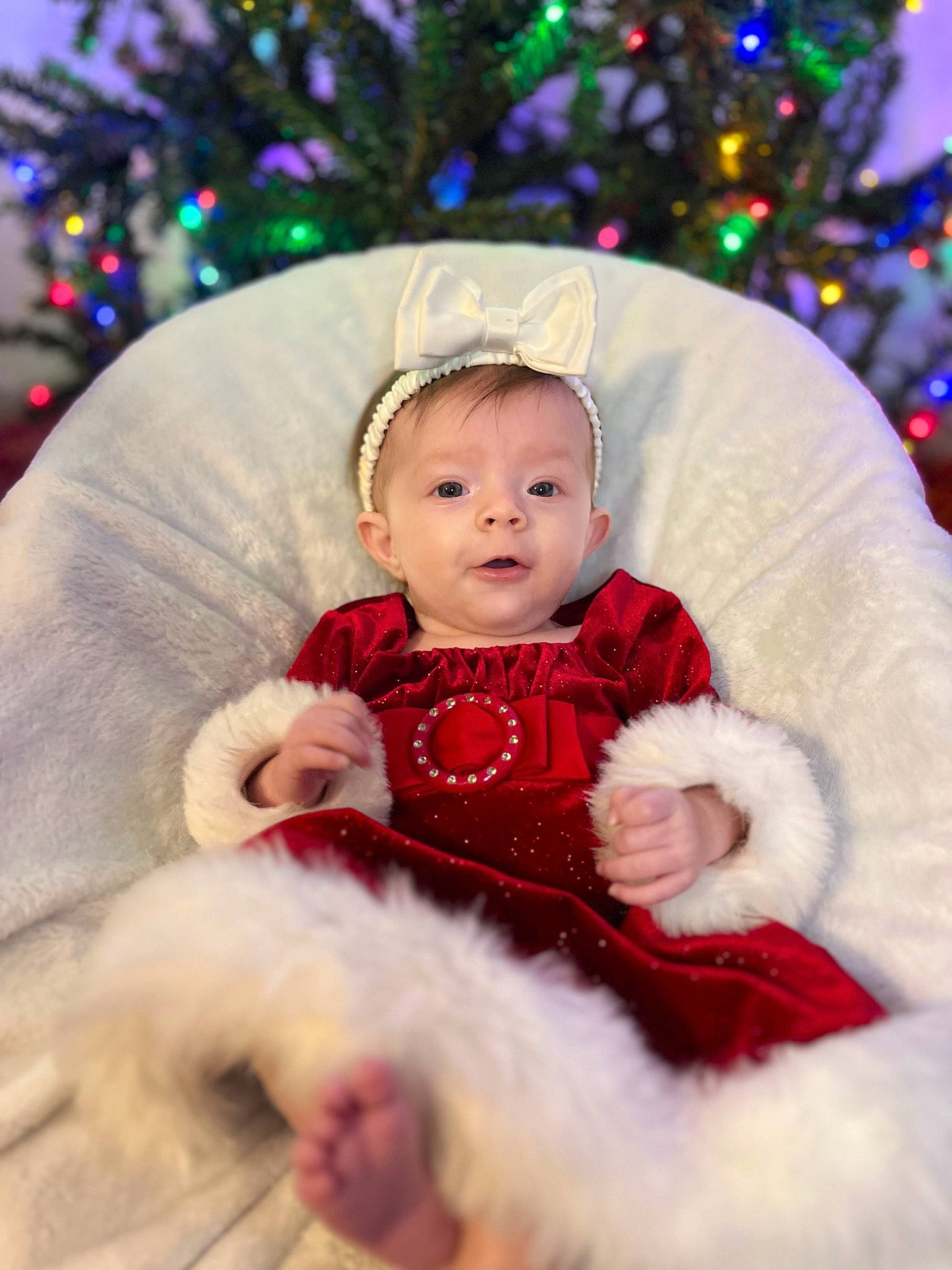 Ava joined the competition — help win amazing prizes! baby, baby_toddler_clothing, child, christmas, christmas_decoration, christmas_ornament, christmas_tree, event, fun, happy, head, holiday, ornament, person, sitting, sleeve, smile, standing, toddler, tree