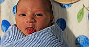 Brayden is registered to the contest to win money with this photo: newborn, baby, infant, blue_blanket, face, tongue_out, wrapped, lying_down, birth_details, sign, patterned_blanket, blue, green, cute, portrait, child, soft_texture, closeup, skin, sleeping_area