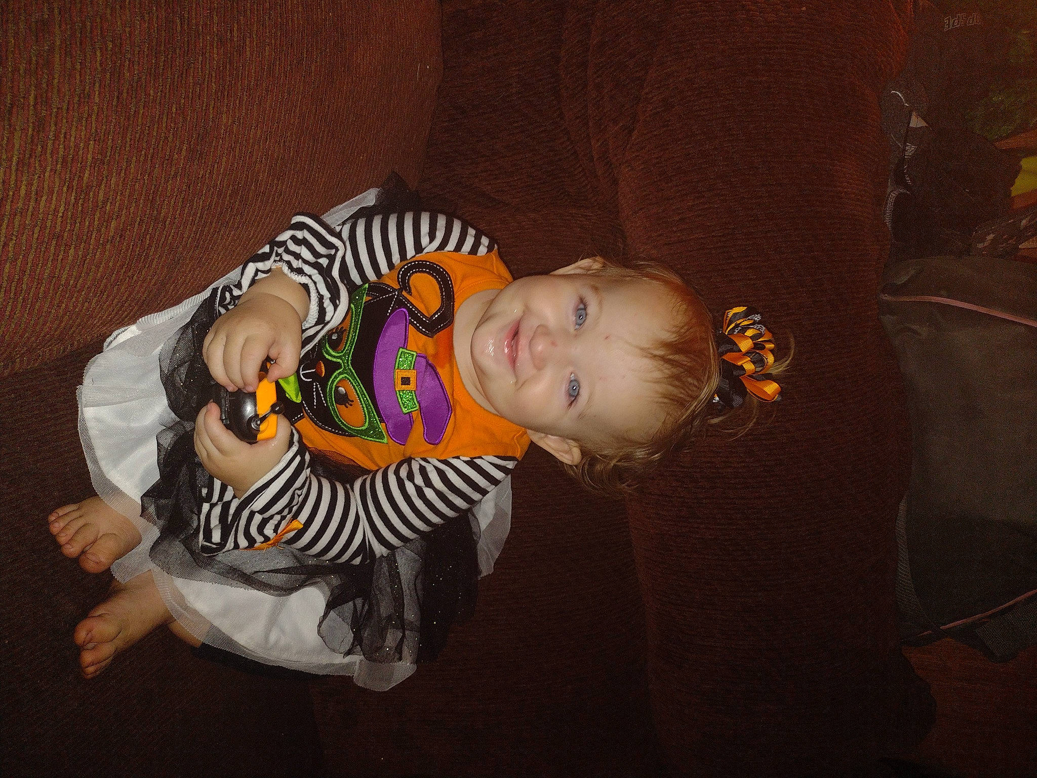 Leila is registered to the contest to win money with this photo: baby, baby_products, baby_toddler_clothing, cheek, child, comfort, couch, darkness, eye, flash_photography, fun, happy, joy, mouth, pattern, person, room, sitting, sleeve, smile