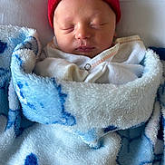 Eric joined the competition — help win amazing prizes! newborn, baby, sleeping, blanket, beanie, hat, red, blue, white, face, closed_eyes, cozy, soft, infant, wrapped, cute, person, headwear, indoors, resting