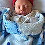 newborn, baby, sleeping, blanket, beanie, hat, red, blue, white, face, closed_eyes, cozy, soft, infant, wrapped, cute, person, headwear, indoors, resting