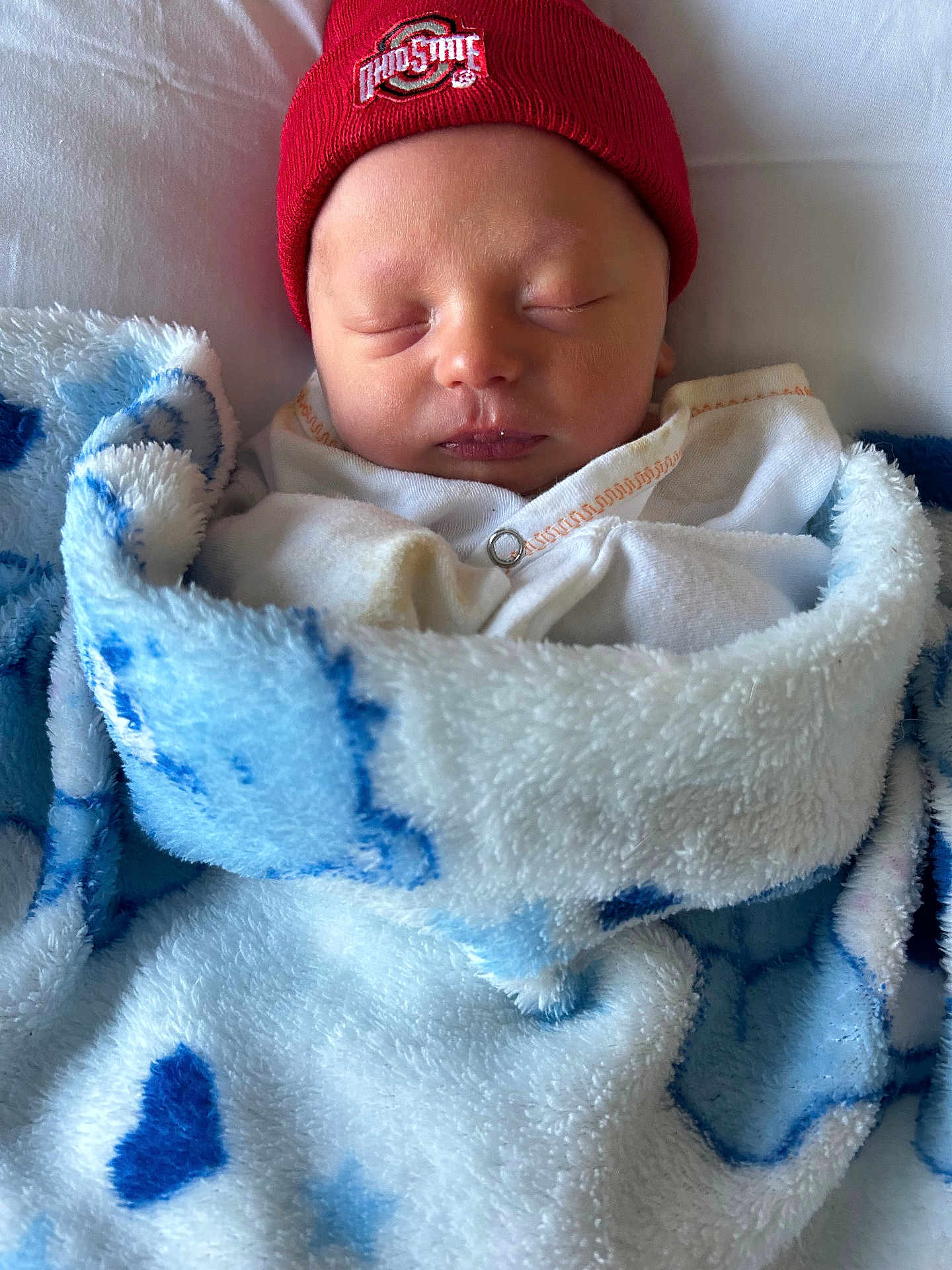 Eric joined the competition — help win amazing prizes! newborn, baby, sleeping, blanket, beanie, hat, red, blue, white, face, closed_eyes, cozy, soft, infant, wrapped, cute, person, headwear, indoors, resting