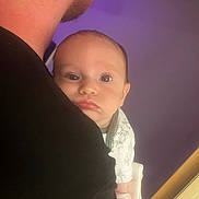 Brewer is registered to the contest to win money with this photo: baby, infant, person, face, adult, shoulder, onesie, clothing, indoor, portrait, expression, curious, holding, close_up, head, skin, human, young_child, parent, background
