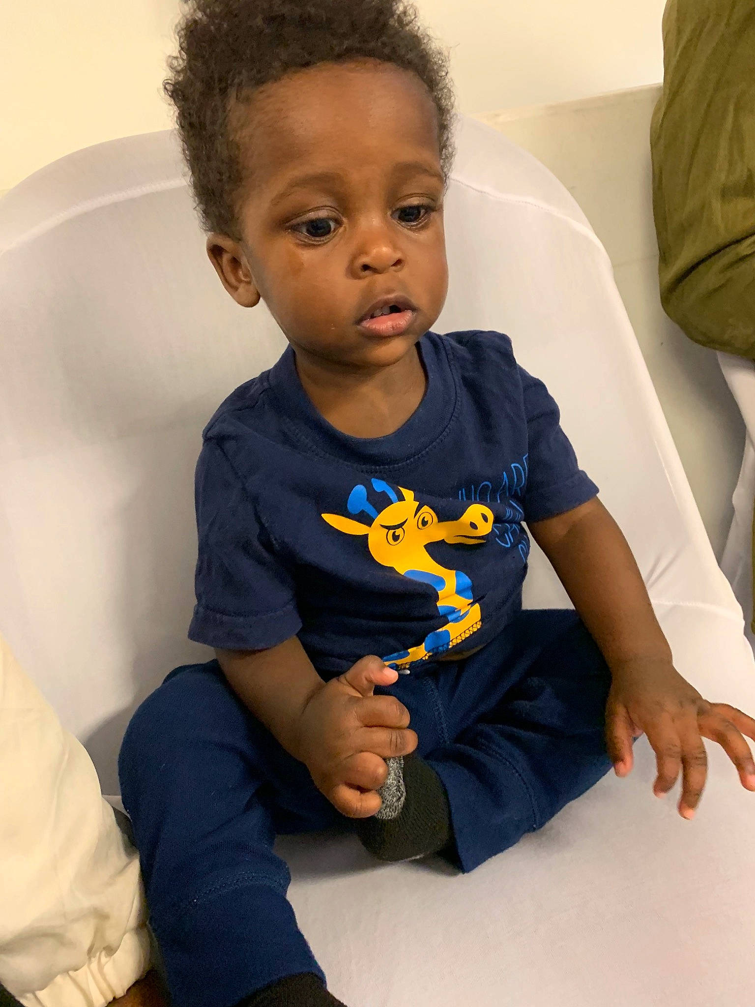 Anari is registered to the contest to win money with this photo: arm, baby, blue, cheek, child, eye, face, hairstyle, head, leg, person, play, sitting, skin, sleeve, t_shirt, toddler, yellow