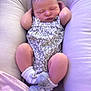 Alayna is registered to the contest to win money with this photo: baby, newborn, sleeping, infant, cushion, soft, socks, bow, floral, clothing, peaceful, resting, cute, portrait, indoors, child, pink, purple, relaxation, comfort