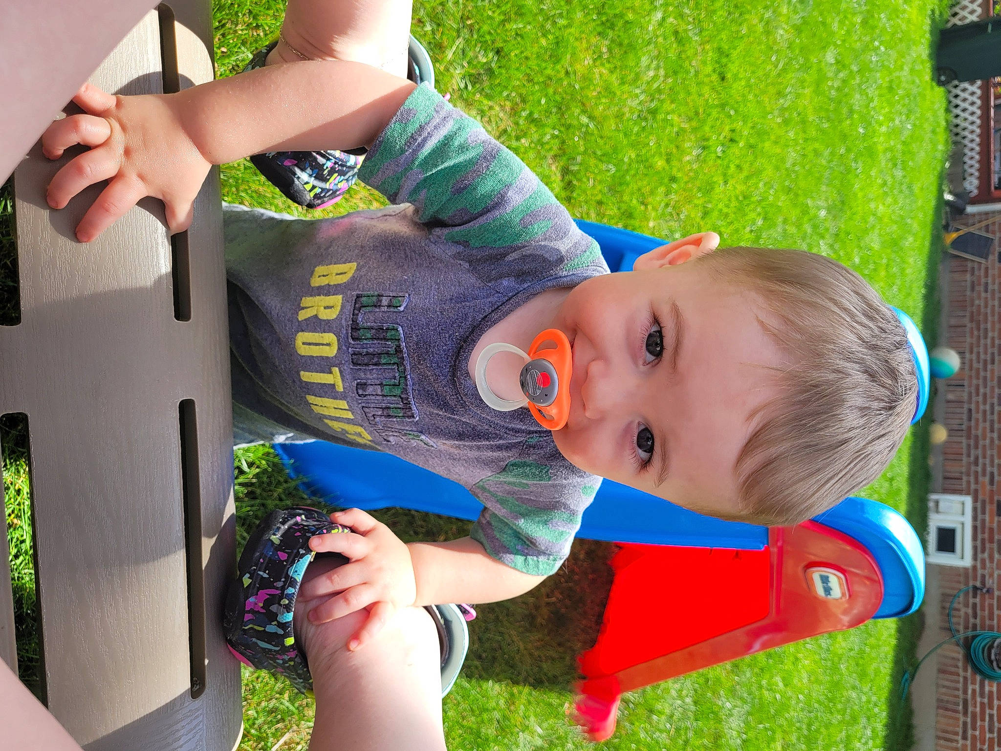 Tyler is registered to the contest to win money with this photo: arm, baby, baby_toddler_clothing, child, electric_blue, facial_expression, finger, fun, grass, green, hand, happy, lawn, leisure, people_in_nature, person, plant, play, recreation, toddler