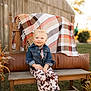 toddler, child, smiling, denim_jacket, cow_print_pants, boots, bench, plaid_blanket, outdoor, grass, wooden_furniture, fall_decor, sunlight, portrait, cute, pigtails, happy, fashion, nature, seasonal