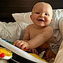 baby, smiling, toy, piano, blanket, bed, child, happy, playful, indoor, cute, infant, face, hand, person, cozy, soft, pillow, skin, expression