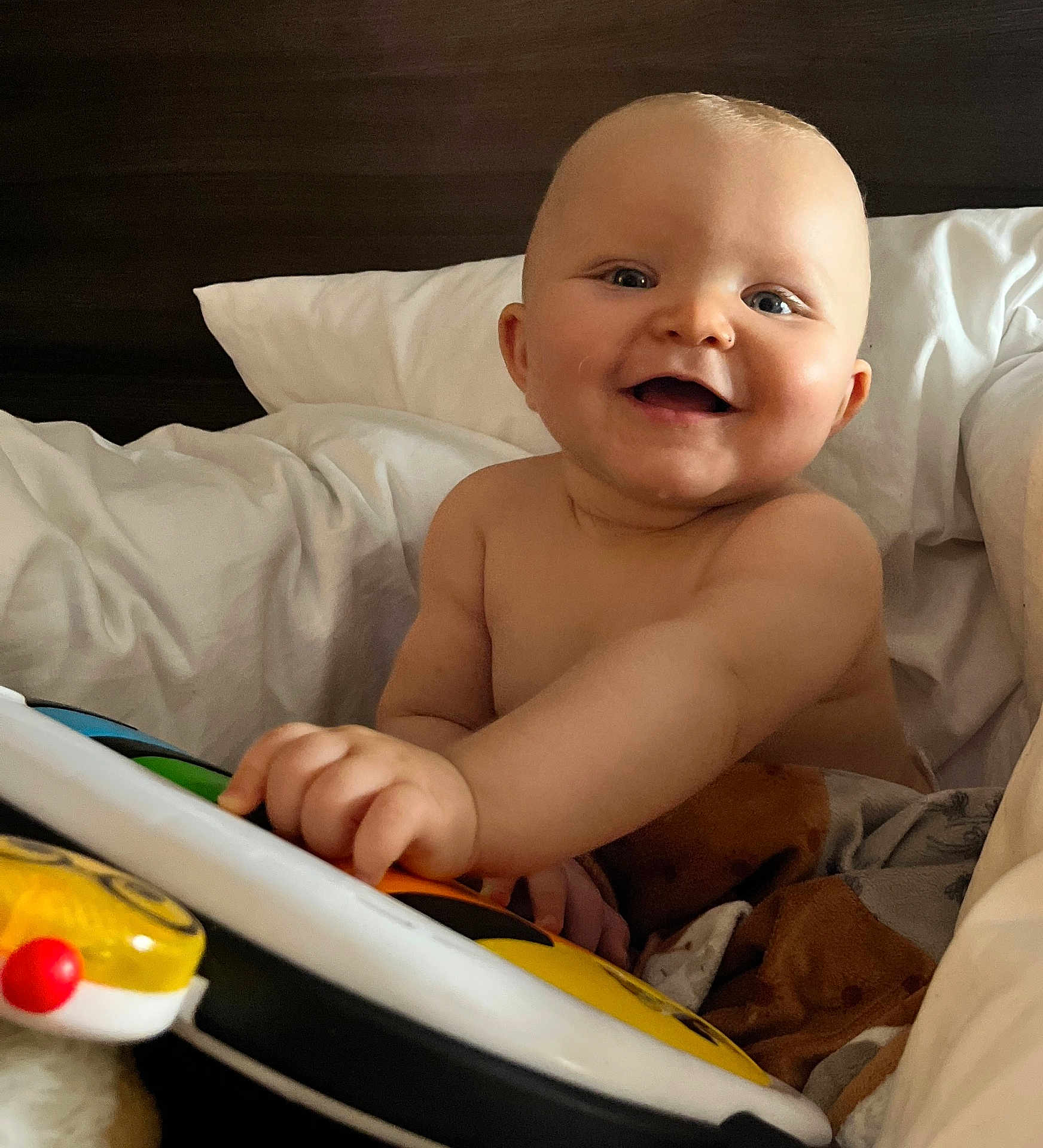Christian-Levi joined the competition — help win amazing prizes! baby, smiling, toy, piano, blanket, bed, child, happy, playful, indoor, cute, infant, face, hand, person, cozy, soft, pillow, skin, expression