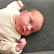 Inna participe au concours pour gagner de l'argent avec cette photo : baby, infant, newborn, face, skin, clothing, hand, lying_down, cute, expression, eyes, fist, soft_texture, fabric, cozy, portrait, child, person, indoor, closeup