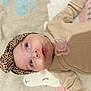 animal_print, baby, beige_clothing, blanket, child, closeup, cozy, curious, cute, eyes, face, head, headband, indoor, infant, lying_down, pacifier, pink, portrait, soft_texture