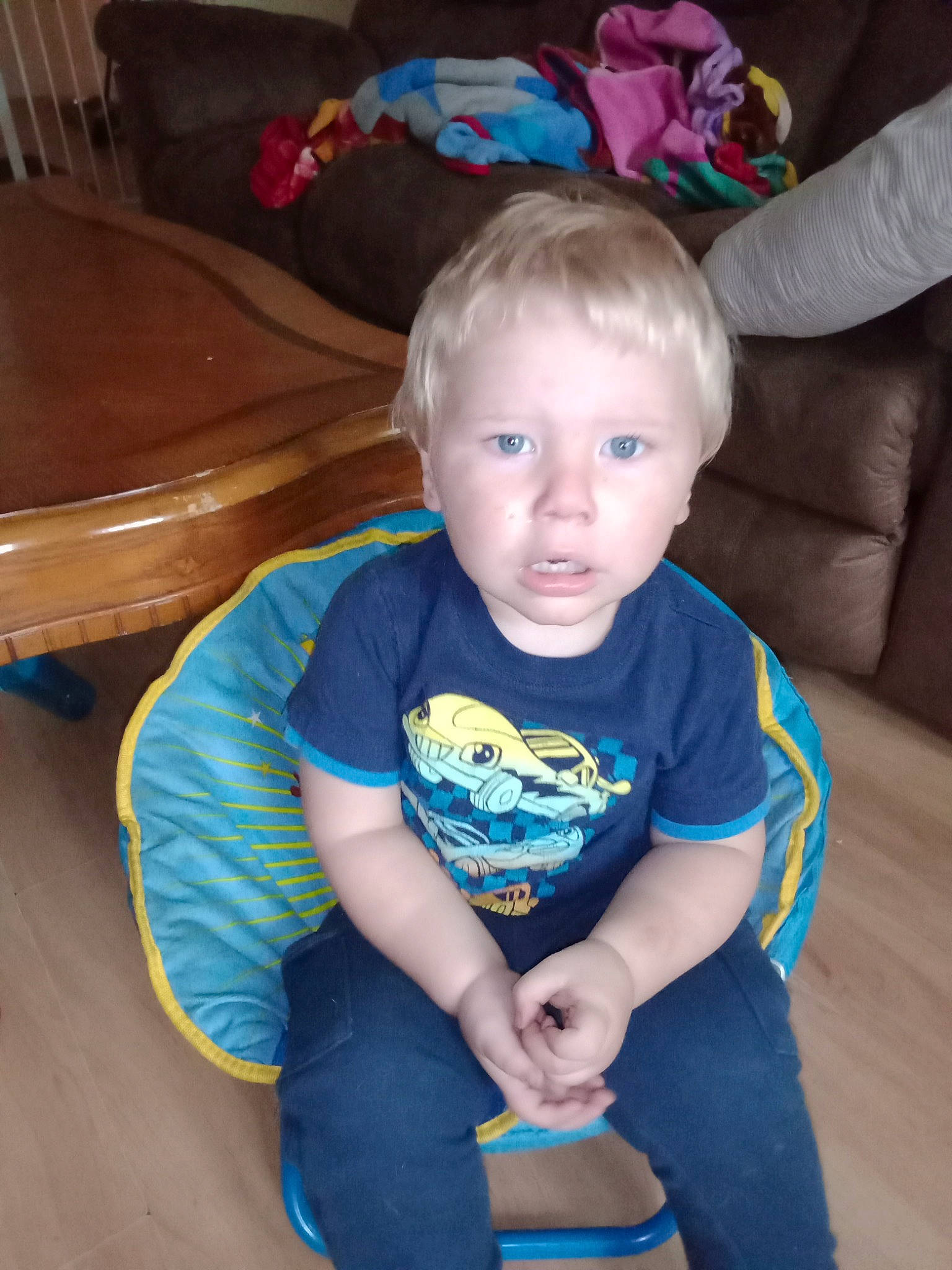 Jacobi is registered to the contest to win money with this photo: baby_toddler_clothing, cheek, child, electric_blue, finger, flooring, fun, human_body, joint, knee, lap, person, sitting, skin, sleeve, smile, standing, t_shirt, thigh, toddler