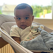 Marceau participe au concours pour gagner de l'argent avec cette photo : baby, infant, plush_toy, shark, baby_rocker, cushion, window, indoor, curious, wide_eyes, clothing, wooden_frame, soft_toy, child, person, portrait, seated, comfortable, home, daylight