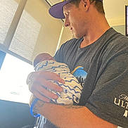 Remington Jr. is registered to the contest to win money with this photo: accessories, adult, baby, baseballcap, cap, clothing, face, glasses, hat, head, indoors, male, man, newborn, person, photography, portrait, skin, t_shirt, tattoo