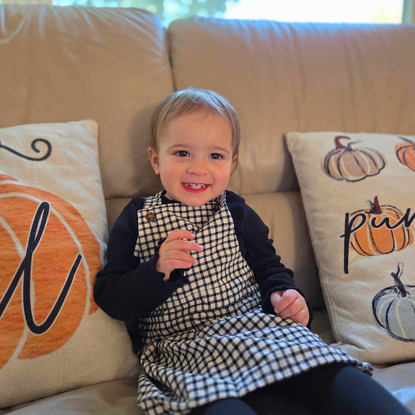 Vana joined the competition — help win amazing prizes! black_sleeves, child, clothing, couch, cozy, cute, dress, face, hair, happy, home, indoor, natural_light, pillows, portrait, pumpkin, sitting, smiling, toddler, window