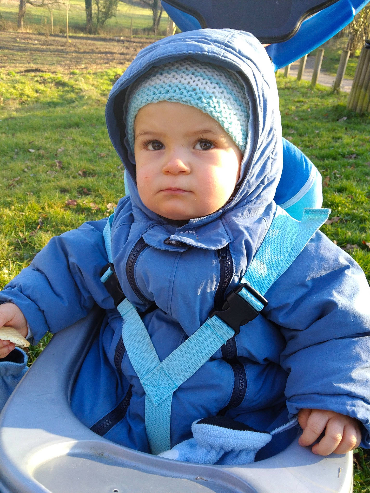 Ylann participe au concours pour gagner de l'argent avec cette photo : baby, baby_products, baby_toddler_clothing, blue, cap, child, electric_blue, fun, grass, green, happy, headwear, jacket, leisure, people_in_nature, person, plant, recreation, sitting, toddler