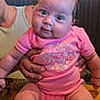 Omi joined the competition — help win amazing prizes! baby, infant, pink_onesie, socks, tattoo, hand, table, restaurant, person, child, cute, smiling, seated, wooden_table, indoor, family, clothing, face, eyes, holding