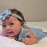 Omi joined the competition — help win amazing prizes! baby, infant, blue_dress, headband, smile, lying_down, blanket, cute, face, hand, cheeks, skin, person, young_child, portrait, indoor, soft_texture, expression, happy, baby_clothing
