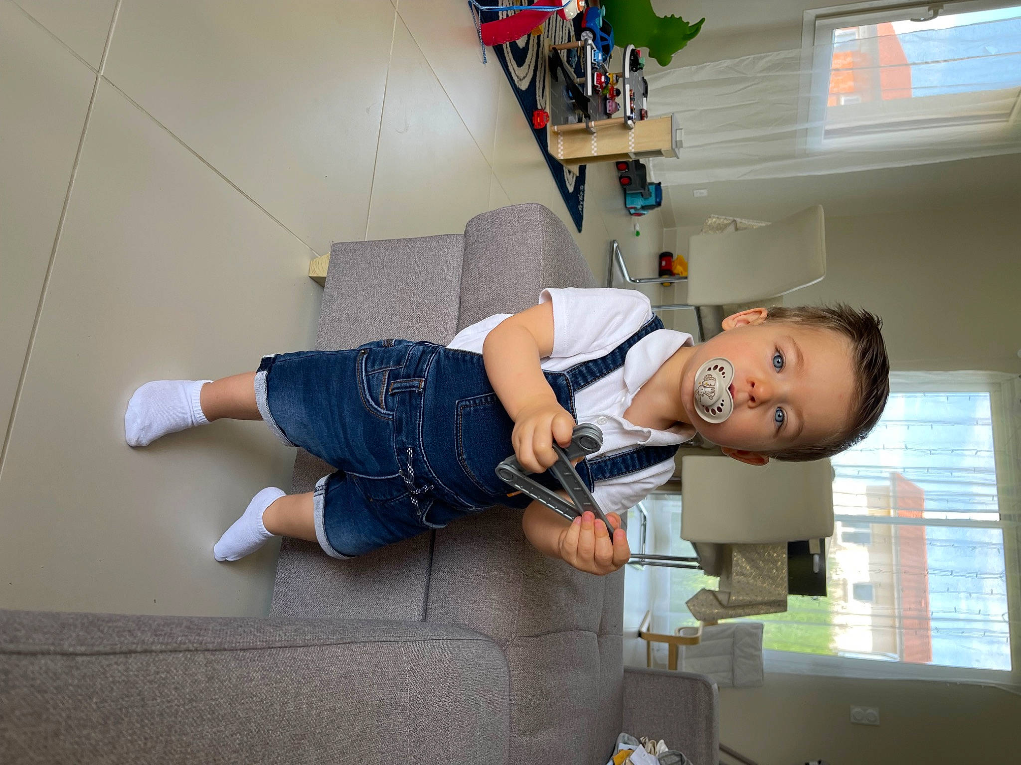 Tao participe au concours pour gagner de l'argent avec cette photo : comfort, denim, elbow, electric_blue, flooring, fun, human_leg, joint, knee, leg, person, room, shelf, sitting, t_shirt, thigh, waist, window