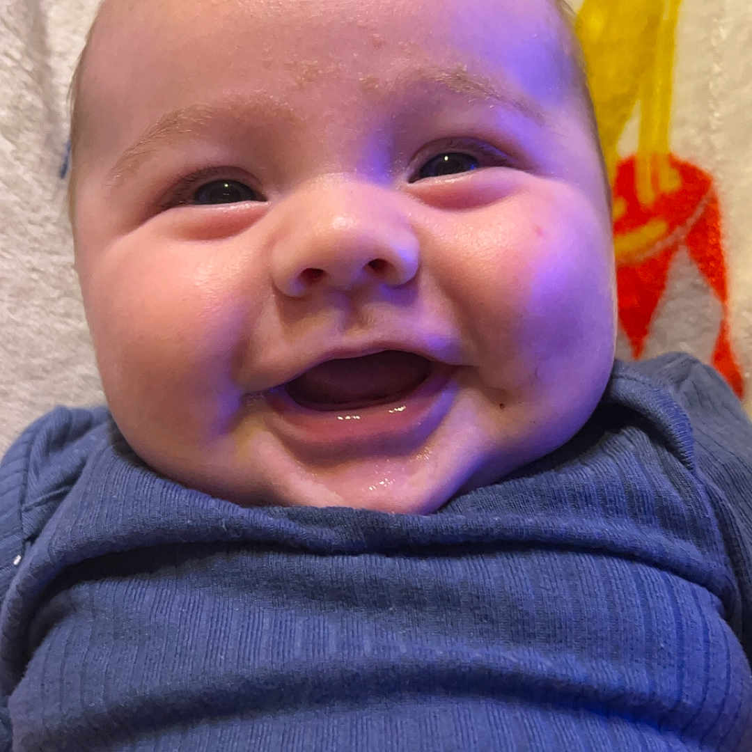 Mason is registered to the contest to win money with this photo: baby, babylaughing, bodypart, clothing, coat, face, happy, head, jacket, knitwear, laughing, mouth, newborn, pants, person, photography, portrait, smile, sweater, teeth