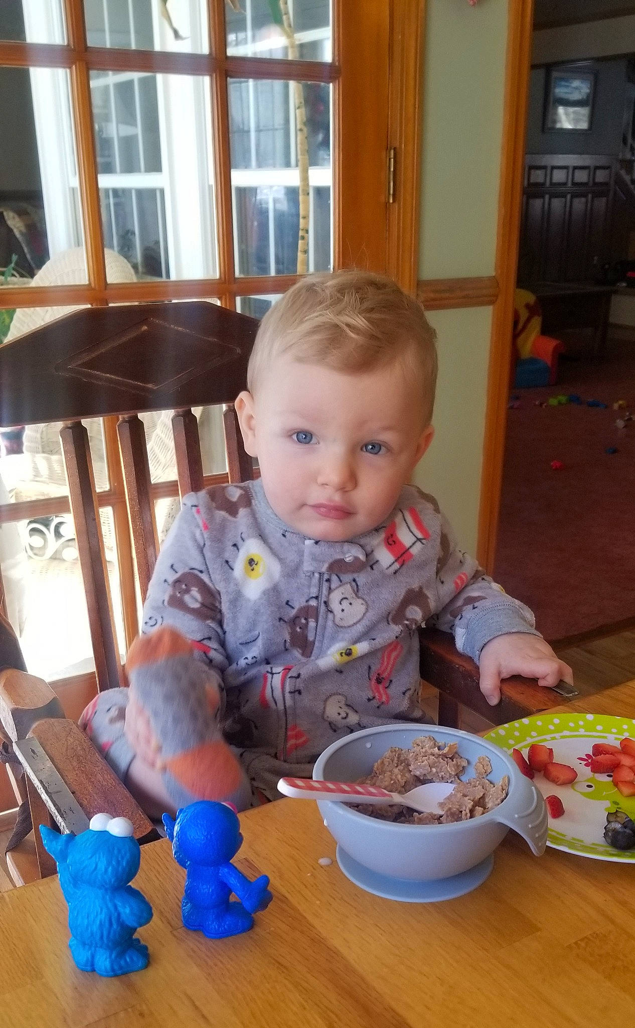 Layne is registered to the contest to win money with this photo: baby, baby_toddler_clothing, bowl, chair, child, comfort_food, eating, flooring, food, fun, hardwood, person, play, room, sharing, spoon, table, tableware, toddler, window