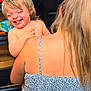 child, toddler, smile, woman, blonde_hair, indoor, holding, happy, person, shoulder, dress, hair, back, skin, face, expression, joy, family, care, love