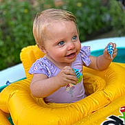 Halle joined the competition — help win amazing prizes! child, toddler, inflatable, pool_float, yellow, toy, blue_eyes, smiling, outdoor, summer, water, play, garden, brick_wall, happy, clothing, person, baby, fun, sunlight