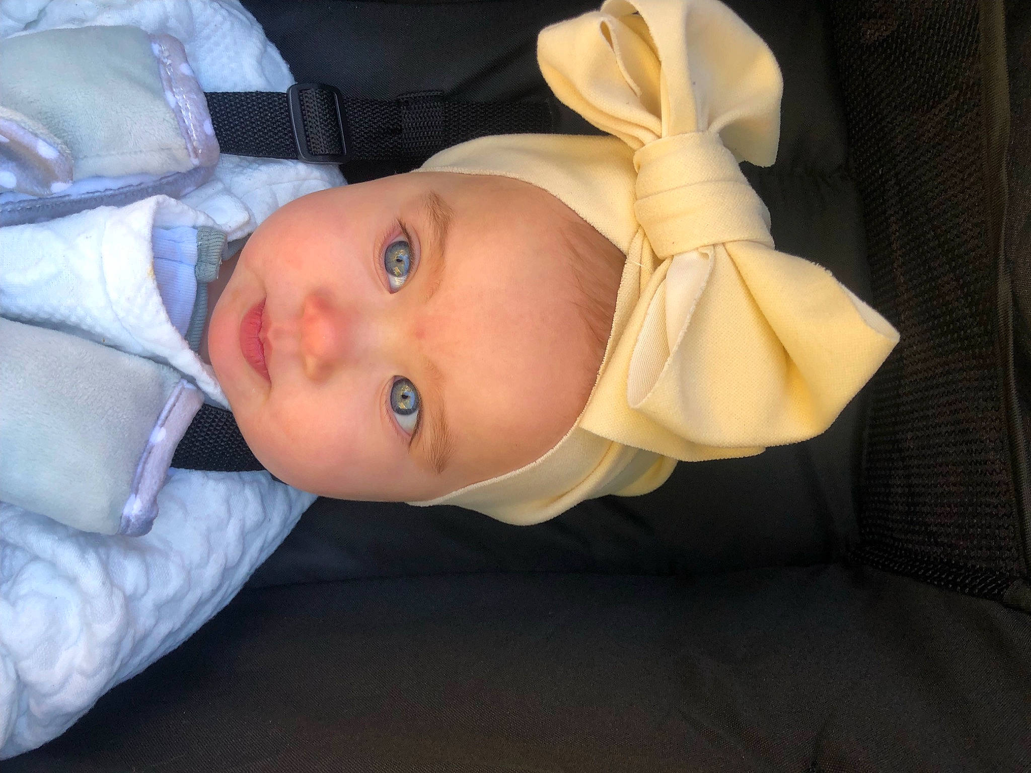 Violet is registered to the contest to win money with this photo: baby, baby_products, baby_safety, baby_toddler_clothing, cheek, child, comfort, eye, eyebrow, hat, headgear, headwear, human_body, lip, nose, person, room, sitting, sleeve, toddler