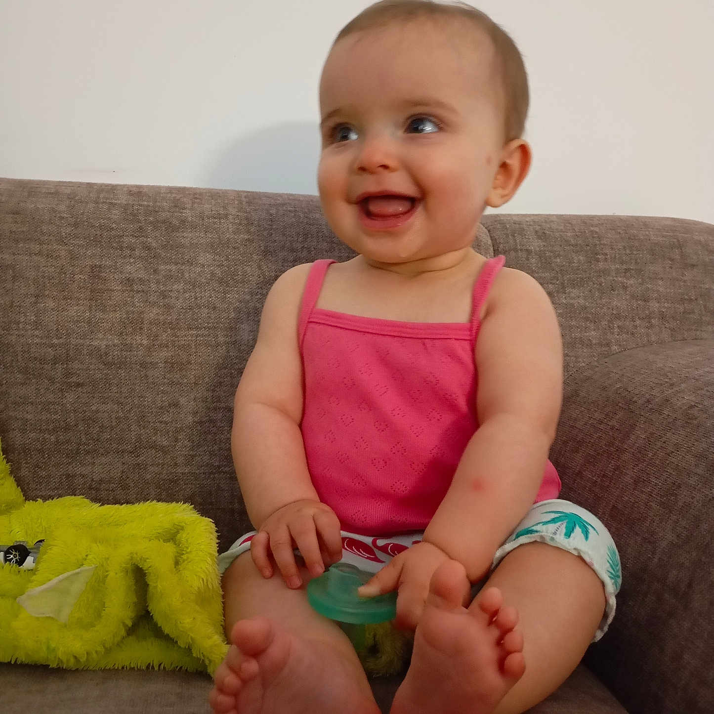 Zyha participe au concours pour gagner de l'argent avec cette photo : baby, barefoot, blanket, child, couch, cute, furniture, fuzzy_blanket, happy, indoor, infant, pacifier, pink_top, relaxed, seated, shorts, skin, smiling, toy, young_child